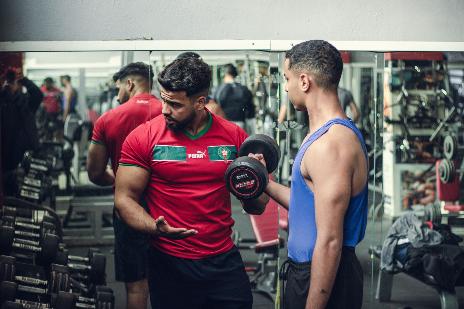 Coach guiding a client with dumbbells